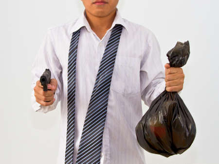 Businessman with a gun and a black bag in hand.の写真素材