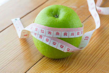 green apple and  measuring tape on wooden background.の写真素材