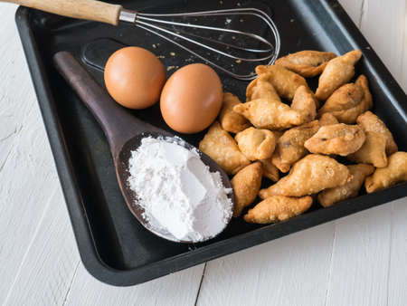 Curry puff, eggs and powder on white wooden backgroundの写真素材