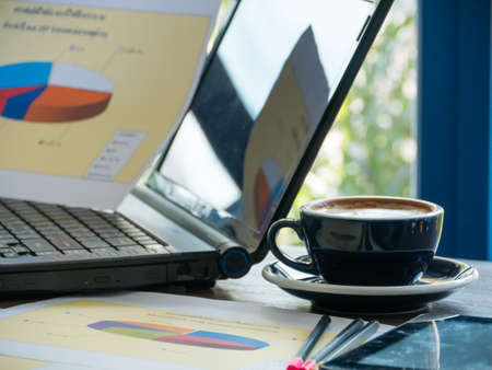 Hot coffee on table in office, blurred glass background,の写真素材