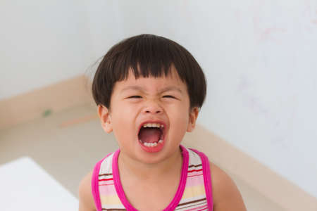Little boy open your mouth shout on white wall background,の写真素材