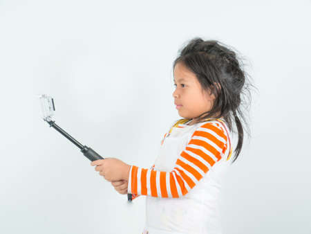 Little girl holding action camera selfie on white background,
