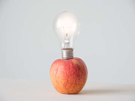 Light bulb in red apple on white background,の写真素材