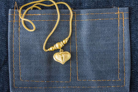 gold necklace on cloth jeans background,の写真素材