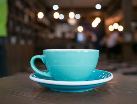 Blue coffee cup on table, light bokeh background,の写真素材