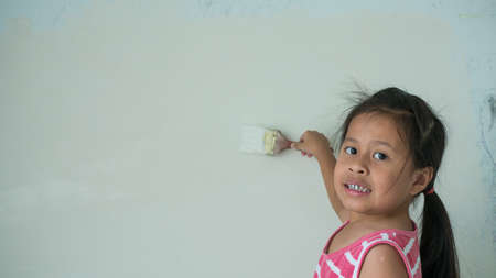 Beautiful asian girl painting wallの写真素材