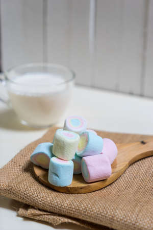Marshmallows in wooden ladle on milk blurred background,の写真素材