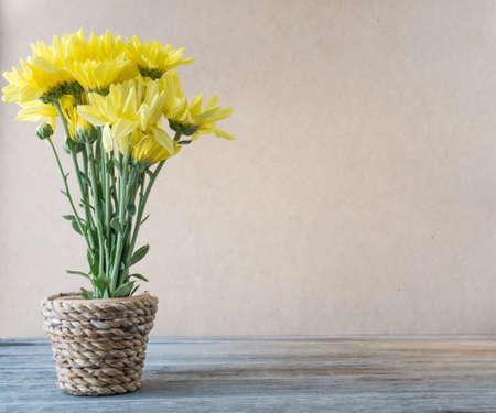 Yellow flower in vase made from bamboo on wooden table,の写真素材
