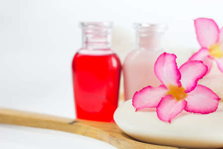 Azalea flowers on piece soap and blur liquid soap background, wooden ladle on white background,の写真素材