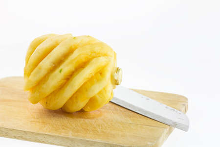 Yellow pineapple on chopping board and on white background,の写真素材