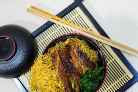Noodle and duck in black cup on white wooden background, top view image,の写真素材