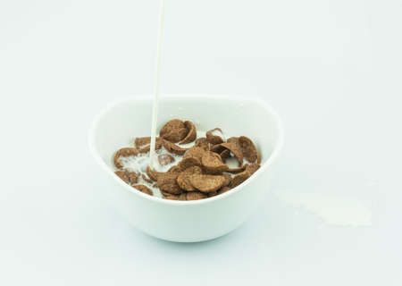 Chocolate cornflake in white cup on white background, milk in cornflake,の写真素材