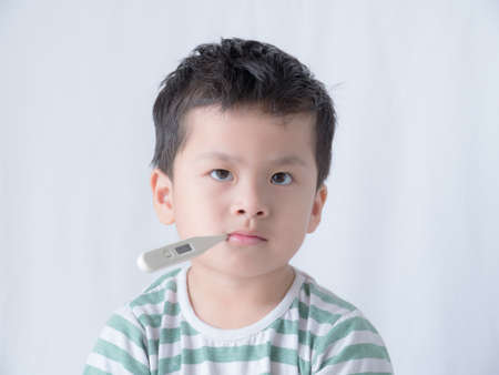Baby sitting with thermometer in his mouth.の写真素材