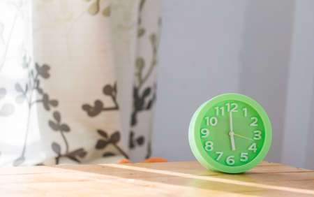 green alarm clock on table.の写真素材