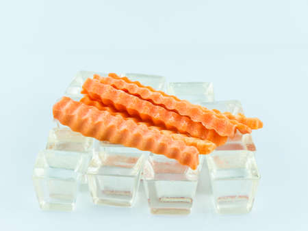 Carrot slices on ice and white background,の写真素材