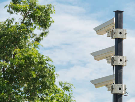 closed-circuit camera on white clouds background and blurred tree background,の写真素材