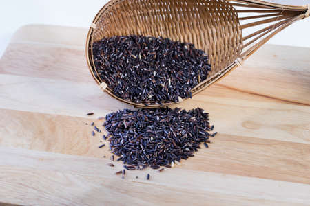 Riceberry rice in bamboo basket on wooden table,の写真素材