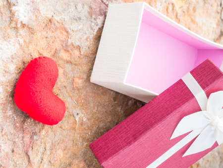 Gift box on rock background, red heart on stone,の写真素材