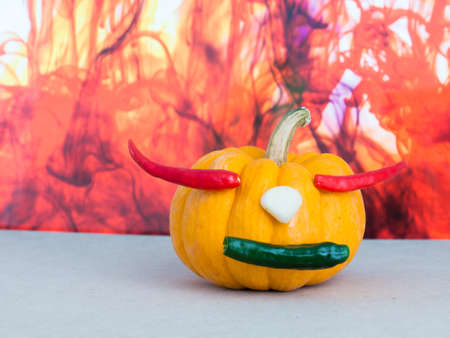 pumpkin on color red background, red chili in pumpkin, yellow pumpkin make mouth by green chili, garlic on yellow pumpkin,の写真素材