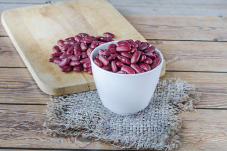 red beans in cup on wood background, red beans on sack,