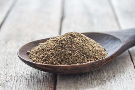 allspice in wooden ladle on wood background.の写真素材