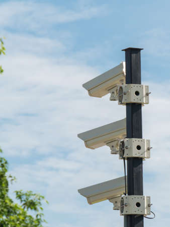 closed-circuit camera on white clouds background and blurred tree background, Vertical CCTV,の写真素材