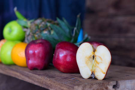 Red apple slice in table on blurred group fruit background,