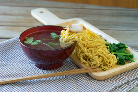 yellow Noodles on side cup soup in wooden table,の写真素材