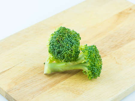 Broccoli in ice on wooden background,