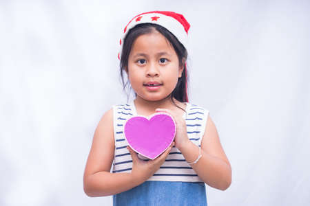 little girl holding box heart on white background,の写真素材