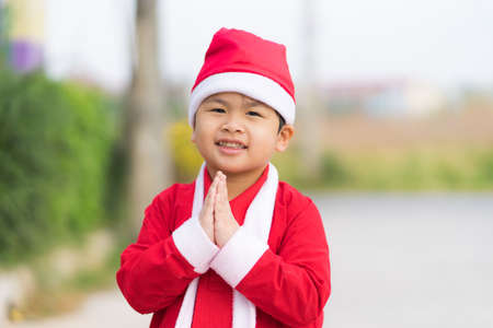 Asian cute boy wear Santa dress holding hand Sawasdee Thailand people,の写真素材