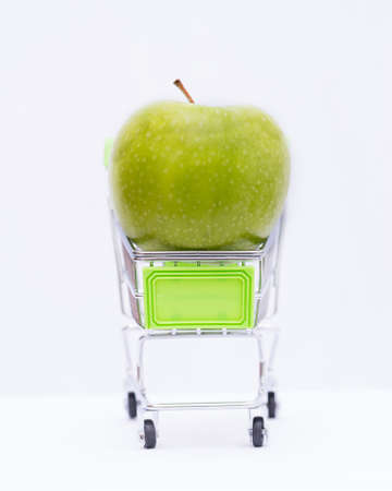 Green apple in toy cart on white backgrond,の写真素材