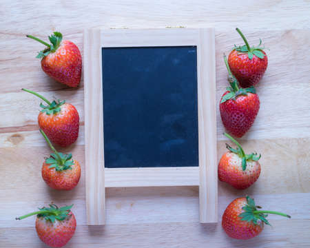 Strawberry and black board on wooden pattern background,の写真素材