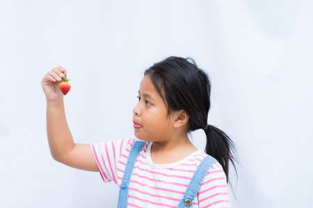 Asian cute a girl holding strawberry on white background,の写真素材