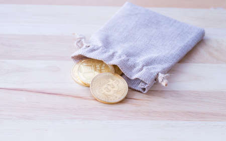 Bag with gold coins on wooden table background, Physical version of Bitcoin, new virtual money.の写真素材