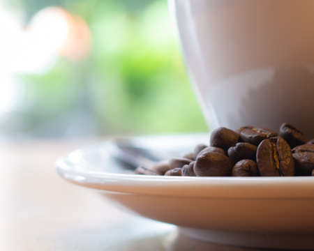 Raw coffee beans on blurred white glass and bokeh background,