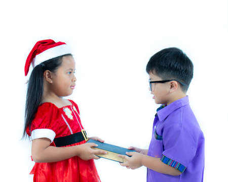 Little girl wearing Santa holding retro a book and boy school cloth wear on white background,の写真素材