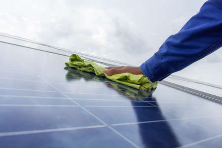Technician holding the towel to wipe the solar cell panelの写真素材