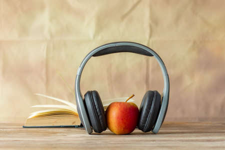 Red apple and earphone on the table with retro wall background,の写真素材