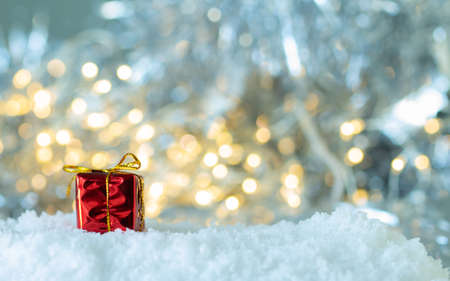 Gifts box in the snow on white bokeh background,の写真素材