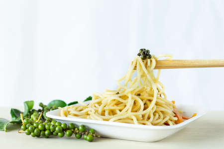 Pepper beads on spaghetti and chopsticks on white background,の写真素材