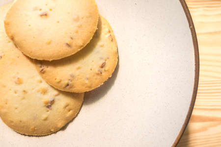 Chocolate chip cookies stack on round plate on wood background