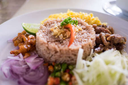 Thai food - Kao Cluk Ka Pi Mixed Cooked Rice with Shrimp Paste Sauce on white round dishの写真素材