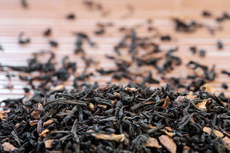 Heap of Dry tea leaves spread on light brown color backgroundの写真素材