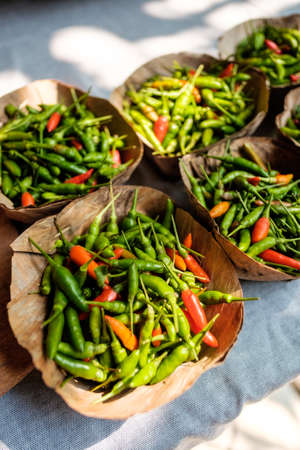 Leaf Bowls filled with red and green Chillies place on table in natural light