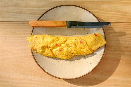 Omelet Roll topped with Salt and Pepper placed on round cream color plate