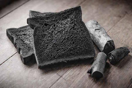 Charcoal breads loaf with charcoal on wooden backgroundの写真素材