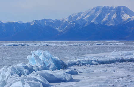 The crack in the ice mountains in the background in winterの写真素材