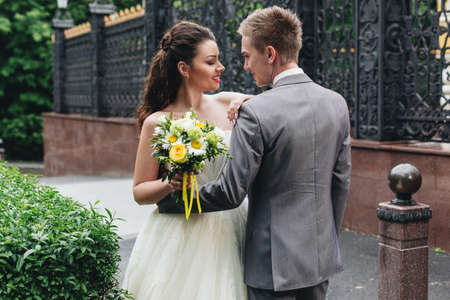Young handsome groom hugging his bride and smiling to her.の写真素材