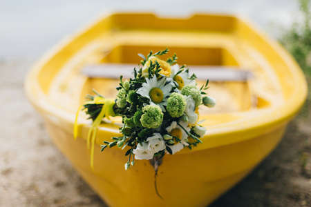 Wedding bouquet lying on the yellow boat.の写真素材